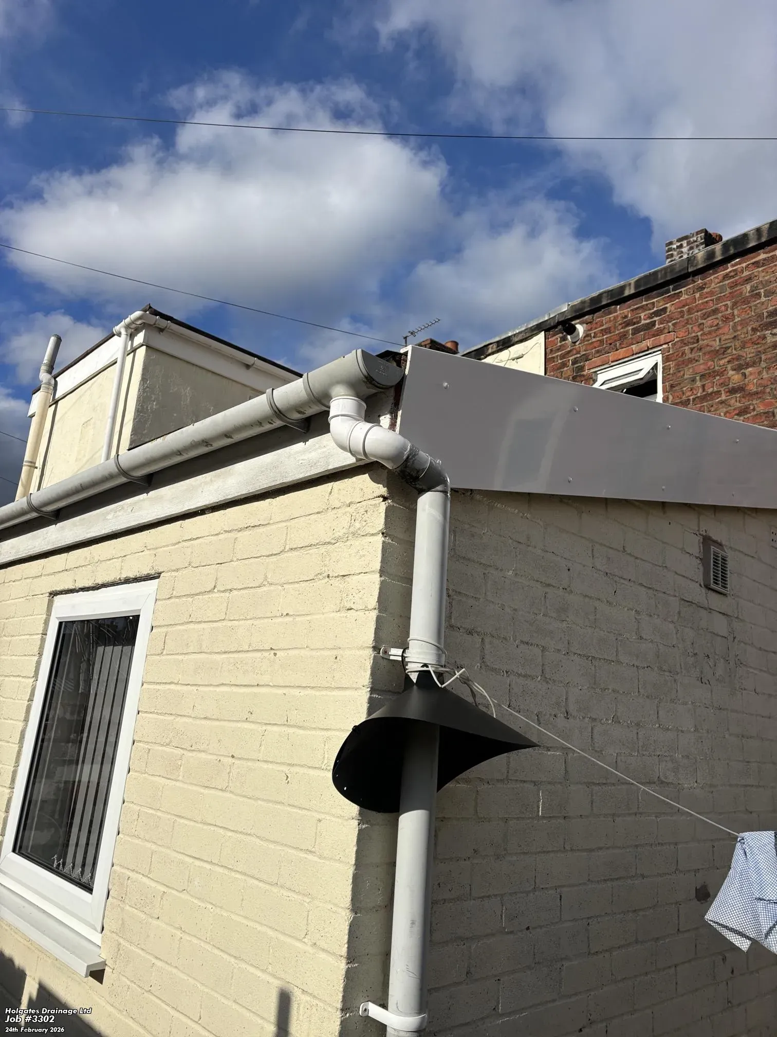 A black rodent guard installed on a building's downpipe for rat and mouse proofing in Blackburn.